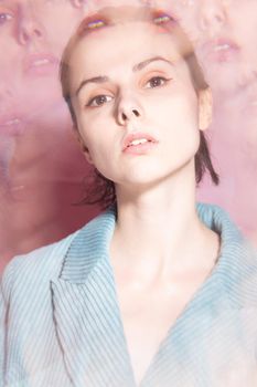 art portrait, a woman in a blue jacket on a pink background. High quality photo
