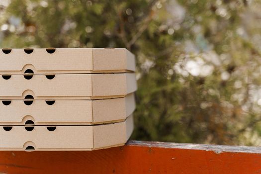 Promotion of 2+2 pizza boxes for food delivery. Isolated photo of 4 cardboard pizza boxes with empty place in right side for text.
