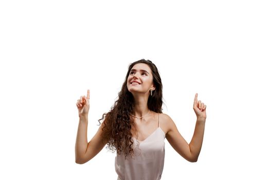 Girl points up and gives 2 variants to choose. Attractive young woman is pointing up and smiles isolated on white background