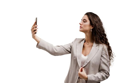 Young business woman does selfie isolated on white background. Attractive girl talking with her friends by video chats. On-line connection with family