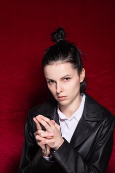 Woman in white shirt and black leather jacket on red velvet background. High quality photo