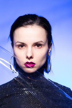 woman with purple lips in a black turtleneck with sequins on a blue background. High quality photo