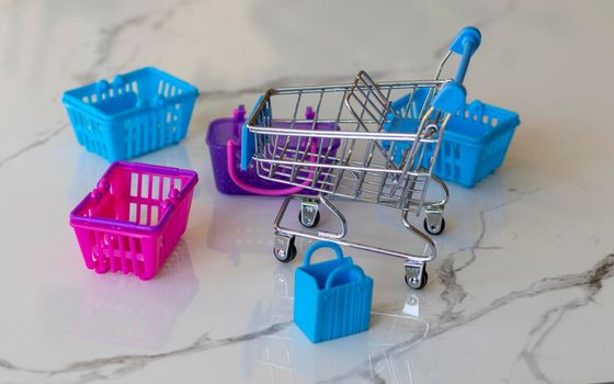 Miniature empty shopping trolley with mini shopping bags