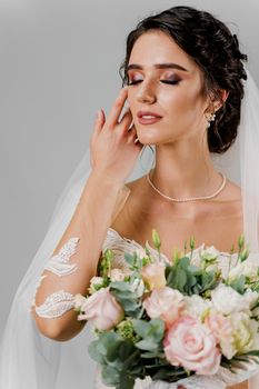 Close-up bride portrait with closed eyes touches her face in studio. Advert for social networks for wedding agency and bridal salon