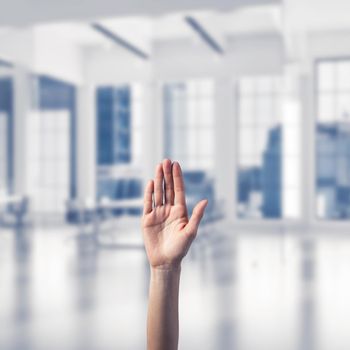 Close of woman hand touching screen with palm and office at background