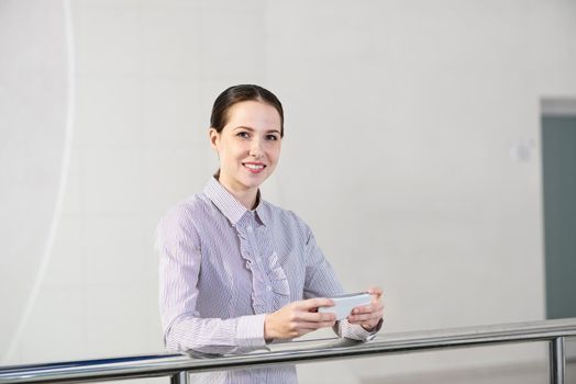 A young woman holds a cell phone. typing in a smartphone.