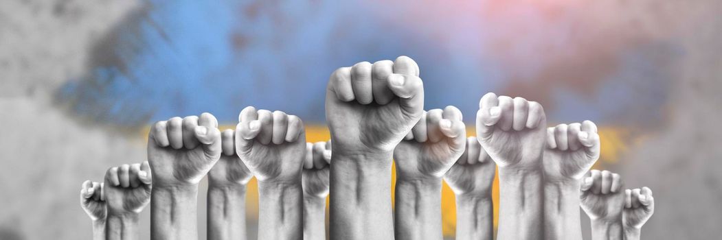 Support for Ukraine and solidarity. Help to the Ukrainian people in wartime. Fists as a symbol of support against the background of the Ukrainian flag. The concept of confrontation and struggle.