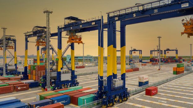 Industrial container yard with crane for business logistic import export, Crane loading cargo container to container ship in the international terminal yard container depot sea port freight shipping.