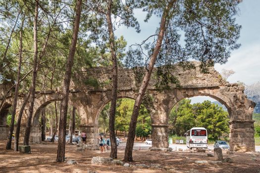 PHASELIS, TURKEY - May 19, 2018. Tourists on ruins of aqueduct of ancient Phaselis city. Famous architectural landmark.