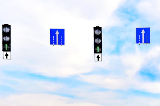 in the direction that one is facing or traveling toward the front.Forward to the future. Green traffic light and a pointer directly against the blue sky.