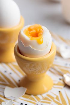 Soft-boiled eggs in a yellow eggcups vertical