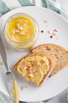 Homemade hummus with pine nuts and bread on a plate