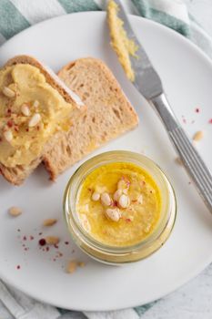 Homemade hummus with pine nuts and bread on a plate