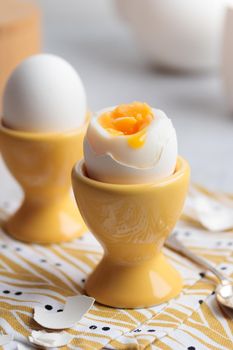 Soft-boiled eggs in a yellow eggcups vertical