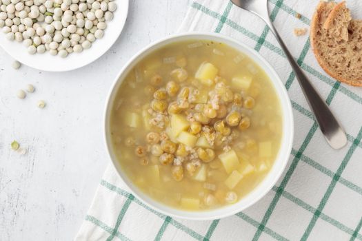 Green pea soup in a large white bowl on a table