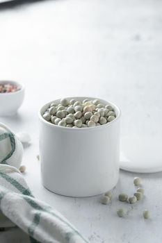 Raw Dried Green Peas in a white bowl on a table