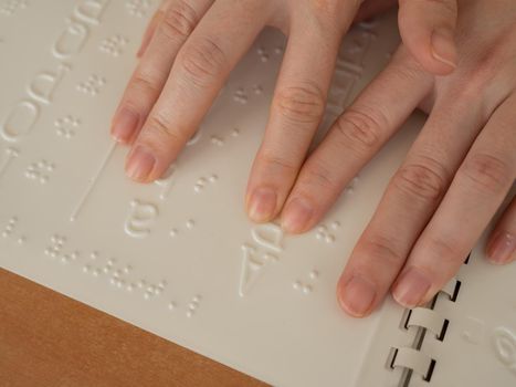 A woman learns the Braille alphabet using a decoder