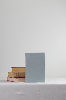 Stack of old rustic vintage books on white table