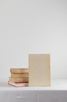 Stack of old rustic vintage books on white table