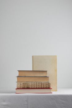 Stack of old rustic vintage books on white table