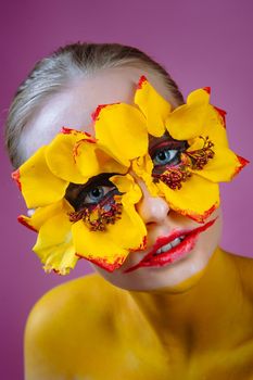 Girl model with yellow flowers around her eyes. Flower Girl