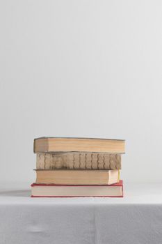 Stack of old rustic vintage books on white table