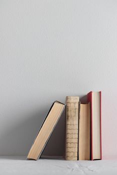 Stack of old rustic vintage books on white table