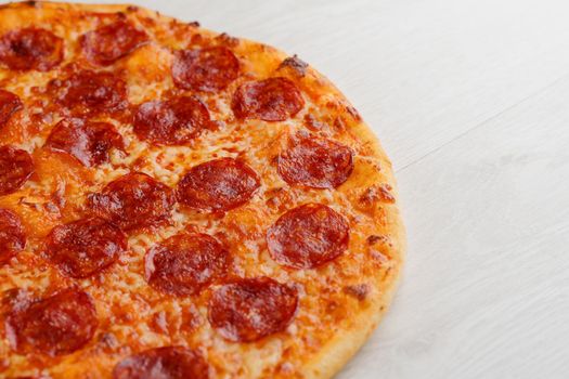 Peperoni pizza with salami, cheese and sauce isolated on white wooden background. Advert for social network of restaurants, caffee. Promotion for pizzeria