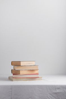 Stack of old rustic vintage books on white table