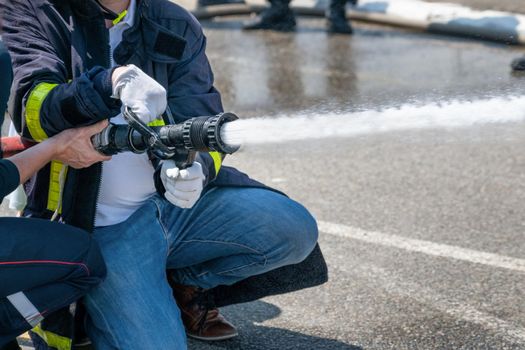 Firefighter shows trainee how to extinguish a fire