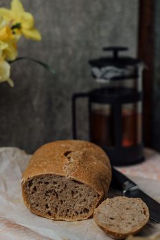 Composition of freshly baked bread on old wooden background.