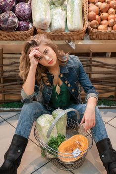 Tired young pretty woman at the supermarket. Very high prices in shops or inflation concept