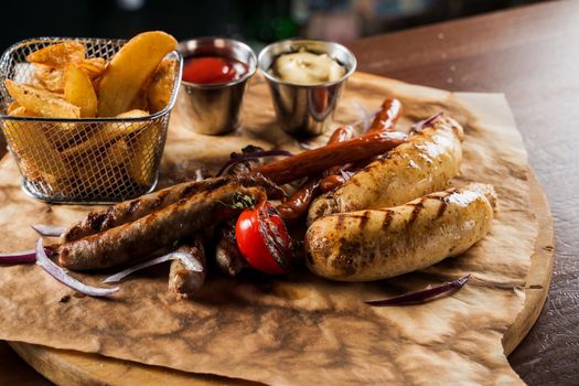Barbecue grilled hot dog with yellow mustard and ketchup on wooden background. Hot dog sandwich with potato fries and sauces.