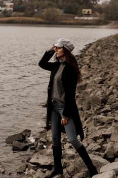 Young woman with curly hair looks at the lake and dreams about her life