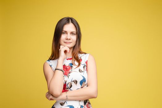 Side view studio portrait of stylish attractive young woman looking away and holding finger. Sudactive feminine model in black with make up plump lips and big eyes holding hand. Concept of style.