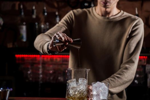 Barman make alcohol cocktail at bar counter. Barman making Jungle Juice coctail in bar
