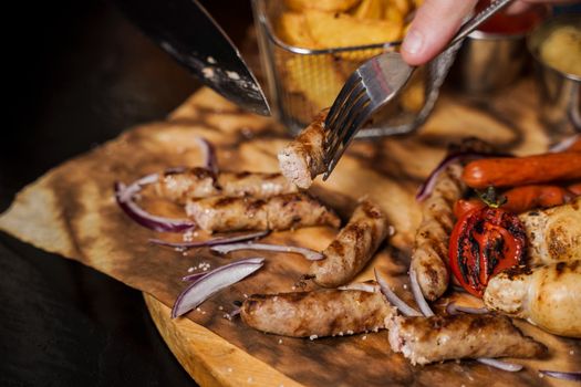 Barbecue grilled hot dog with yellow mustard and ketchup on wooden background. Hot dog sandwich with potato fries and sauces.