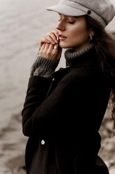 Young woman with curly hair looks at the lake and dreams about her life