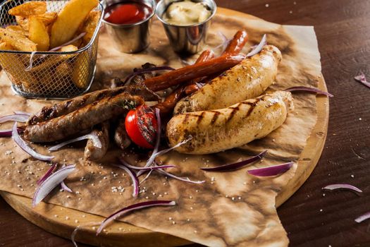 Barbecue grilled hot dog with yellow mustard and ketchup on wooden background. Hot dog sandwich with potato fries and sauces.