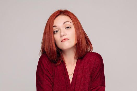 Front view of beautiful business woman wearing in red with short haircut having disregard and passive emotion, looking at camera. Girl do not understanding why and looking frustrated.