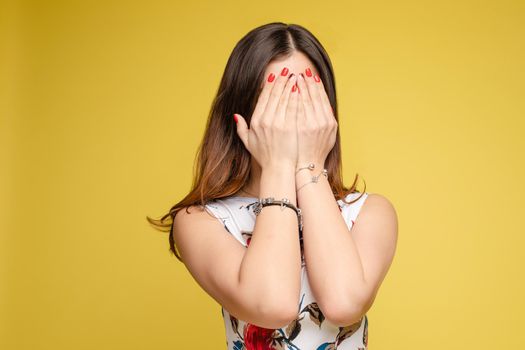 Waist up portrait of surprised beautiful girl with nice long hair, perfect makeup and fashion manicure. She is looking at camera with astonishment. Isolated on dark background