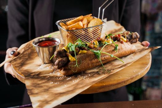 Barbecue grilled hot dog with yellow mustard and ketchup on wooden background. Hot dog sandwich with potato fries and sauces