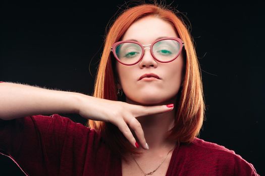 Ill young woman with closed eyes and opened mouth shouting because of her sore throat. Girl with ginger hair having pain in neck or throat. Beautiful model wearing spectacles.