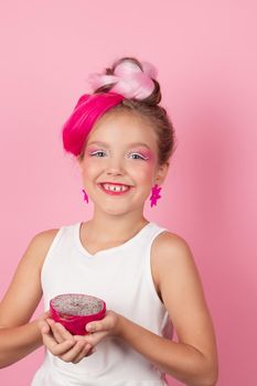 sweet Girl is holding a Pitahaya near her face. A pitaya fruit hold in hand on pink background. Tropical Dragon Fruit cut in half. space for text