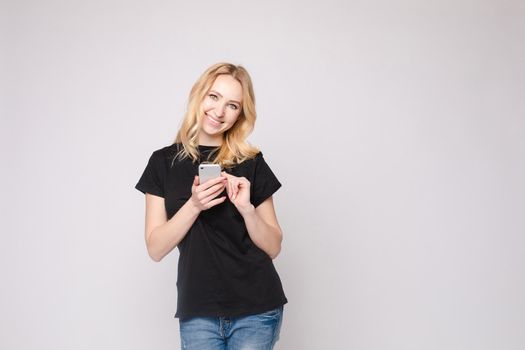 Studio portrait of beautiful caucasian brunette woman in patterned overall pointing at her smartphone with index finger. She is certain or sure about something. I know gesture.