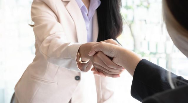 Close up of Business people shaking hands, finishing up meeting, business etiquette, congratulation, merger and acquisition concept.