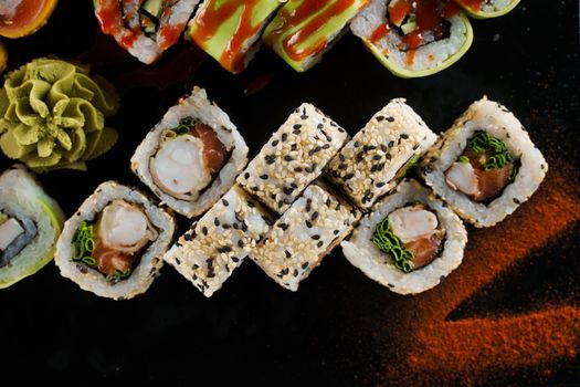 Sushi set close-up on black background. Traditional Japanese seafood. Delicious roll. Advert for food delivery service