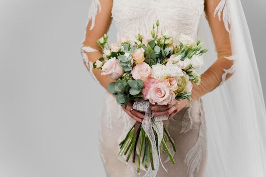 Wedding green bouquet with eucalyptus, roses, peonies in woman hands in studio on white blank background. Close-up bouquet advert for florist
