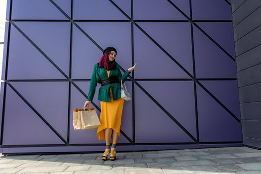 A happy shopaholic girl throws her bags near a shopping center. Have fun shopping on Black Friday. the girl in the store is happy with her purchases, throws packages. Consumer concept