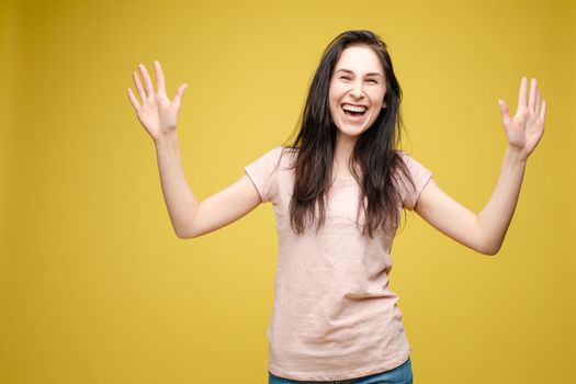 Waist up portrait of surprised beautiful girl with nice long hair, perfect makeup and fashion manicure. She is looking at camera with astonishment. Isolated on dark background